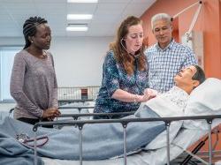 School of Nursing faculty and MSN students demonstrating functions of an intelligent simulator.