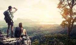 Student on cliff with sunset